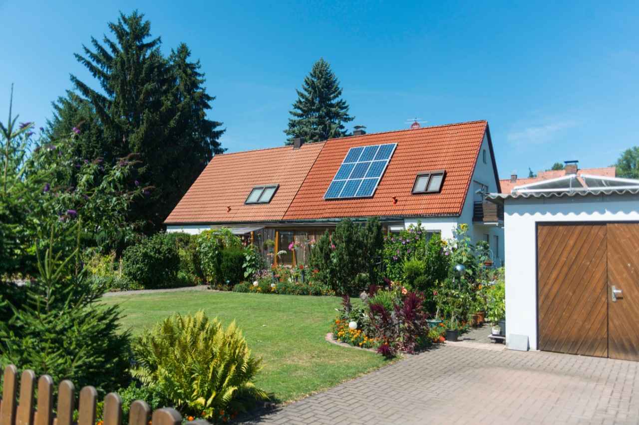 imagen del exterior de una vivienda que tiene un panel fotovoltaico instalado en su tejado 